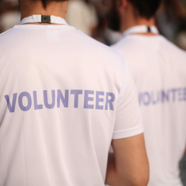 Image of two people wearing shirts that say "Volunteer"